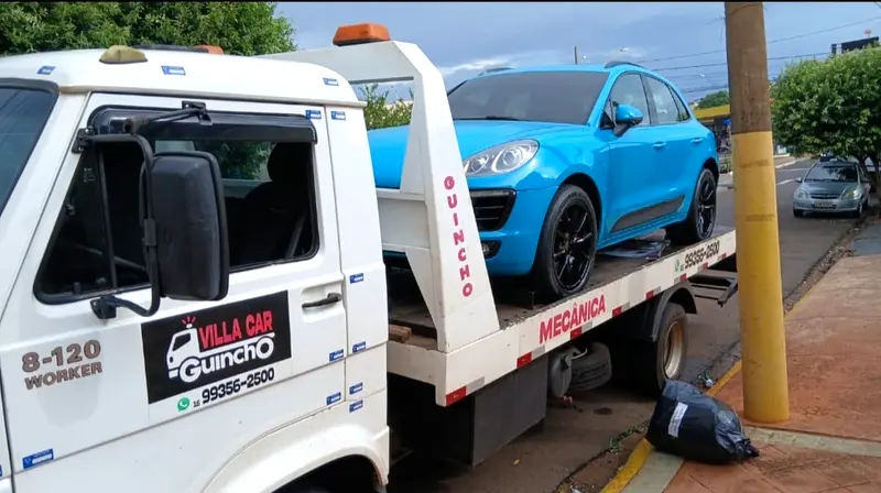 Guincho plataforma da Vila Car transportando um Porsche Macan azul em RibeirÃ£o Preto