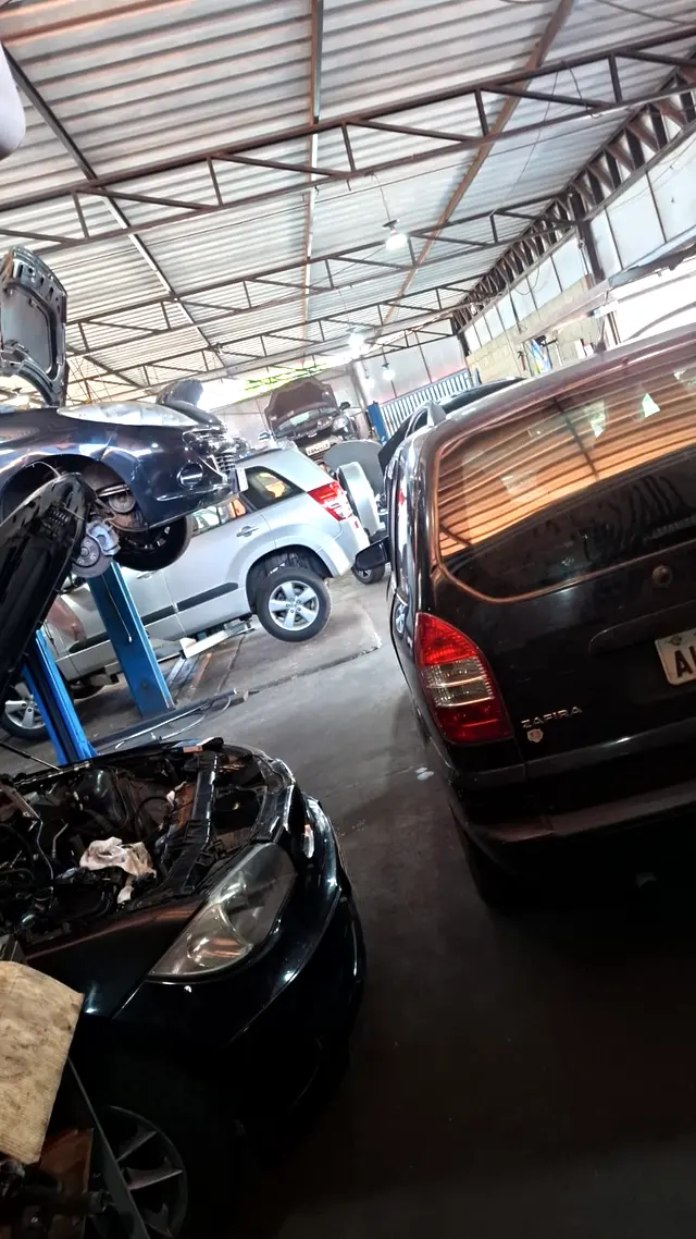 Interior da oficina Vila Car com carros de vÃ¡rias marcas em elevadores